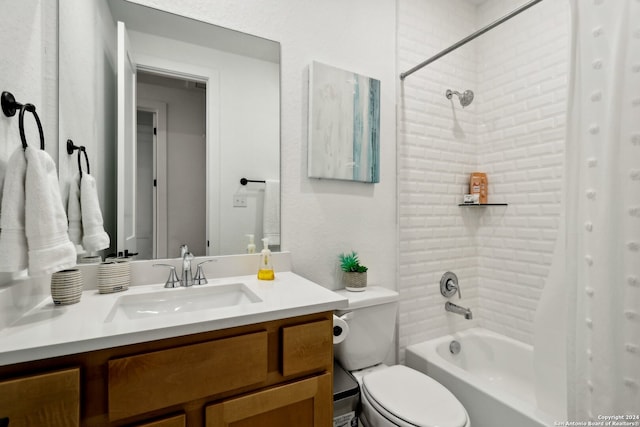 full bathroom with tiled shower / bath, vanity, and toilet