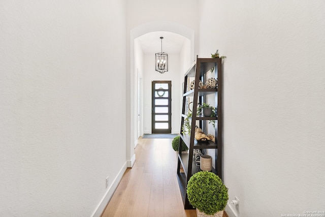 hall featuring a notable chandelier and light hardwood / wood-style floors