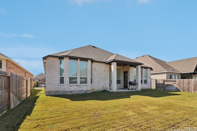 rear view of property featuring a patio and a yard