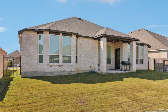 rear view of property with a yard and a patio