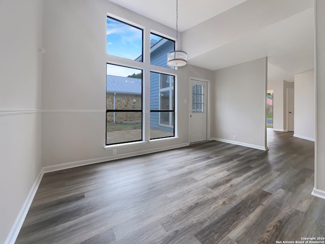 unfurnished dining area featuring dark wood-type flooring