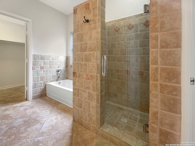 bathroom with tile walls, tile patterned floors, and separate shower and tub