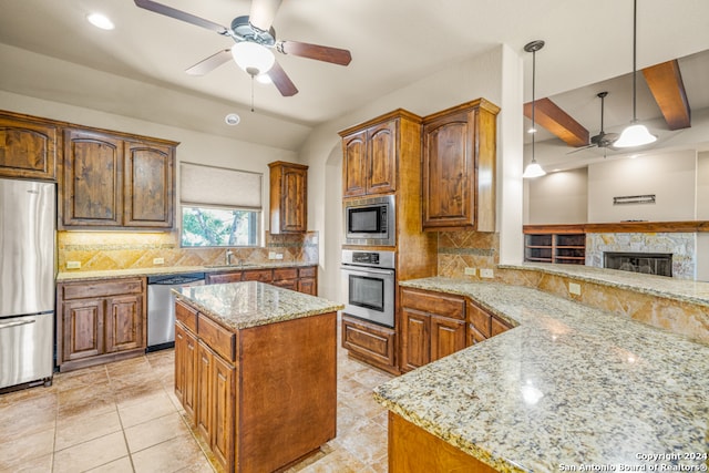 kitchen with light stone countertops, stainless steel appliances, backsplash, and pendant lighting