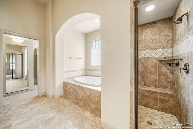 bathroom featuring plus walk in shower and tile patterned flooring