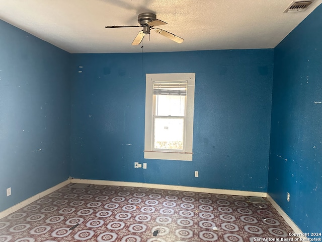 spare room with a textured ceiling and ceiling fan