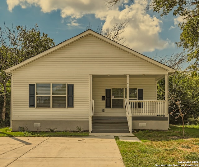 bungalow-style home featuring a porch, crawl space, and a front yard