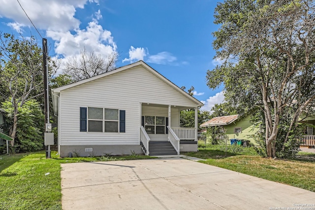 bungalow-style home featuring covered porch, crawl space, and a front yard
