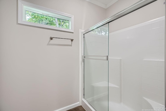 bathroom with a shower stall, baseboards, and wood finished floors