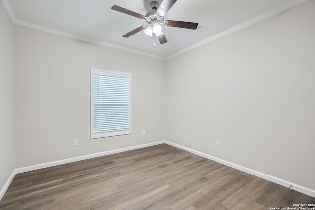 empty room with baseboards, crown molding, wood finished floors, and ceiling fan