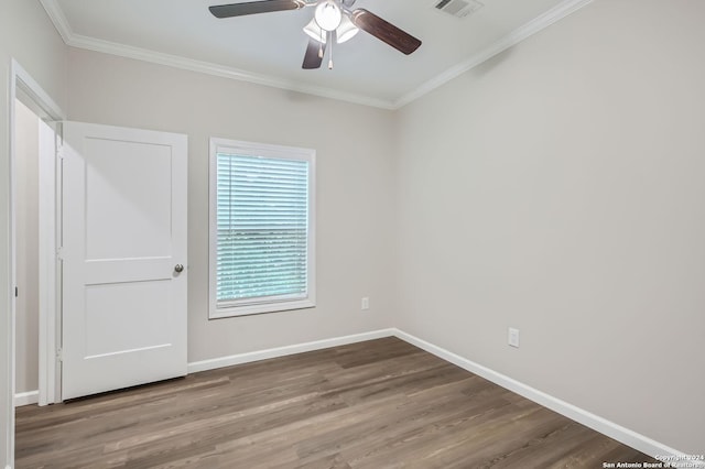 unfurnished bedroom with ornamental molding, wood finished floors, baseboards, and ceiling fan