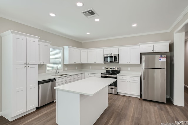 kitchen featuring white cabinets, stainless steel appliances, sink, and a kitchen island