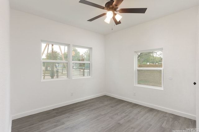 spare room with hardwood / wood-style flooring, plenty of natural light, and ceiling fan