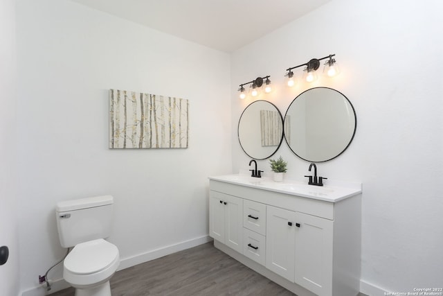 bathroom featuring toilet, hardwood / wood-style floors, and vanity