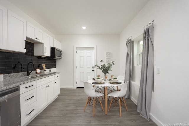 kitchen featuring sink, light stone countertops, white cabinets, appliances with stainless steel finishes, and dark hardwood / wood-style flooring