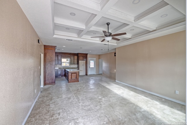 unfurnished living room featuring ceiling fan, coffered ceiling, beamed ceiling, and ornamental molding