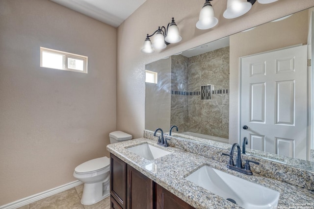 144 W Brazos St, Uvalde, TX 78801 - full bathroom with double vanity, toilet, baseboards, and a sink