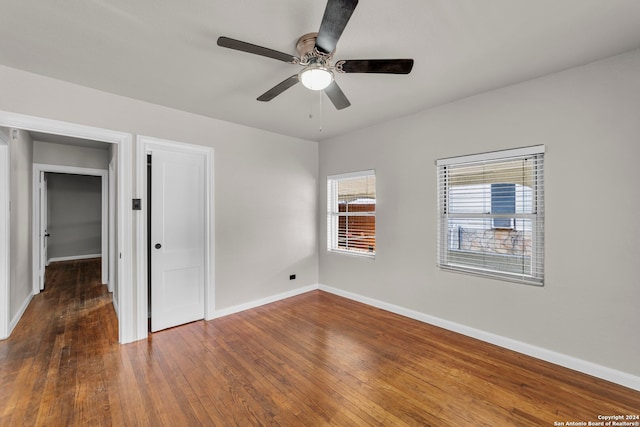 unfurnished room with dark hardwood / wood-style floors and ceiling fan