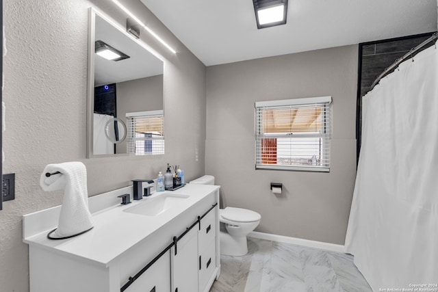 bathroom with vanity, toilet, a healthy amount of sunlight, and walk in shower