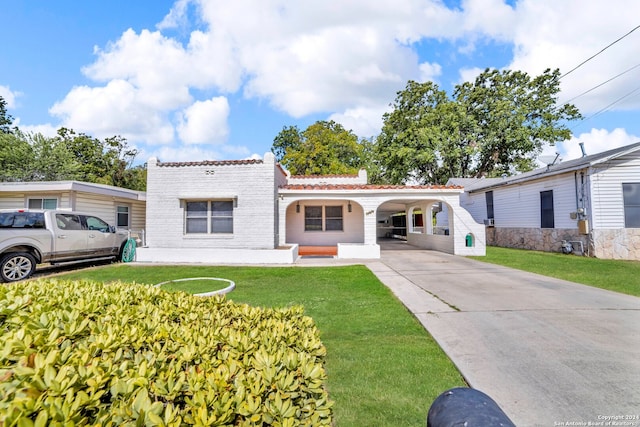 mediterranean / spanish-style home featuring a front yard and a carport