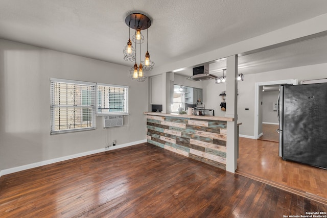 interior space with cooling unit, dark hardwood / wood-style floors, and a textured ceiling