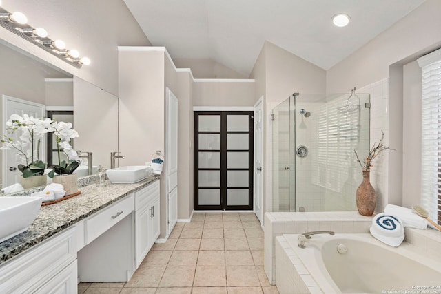 bathroom featuring vanity, lofted ceiling, plus walk in shower, and tile patterned flooring