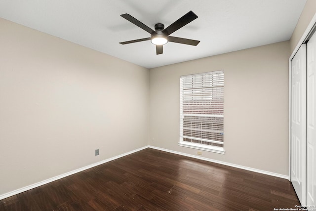 unfurnished bedroom featuring dark wood-type flooring, ceiling fan, and a closet