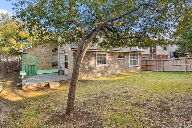 back of property featuring a deck and a yard