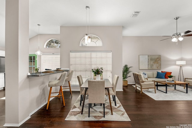 dining room with ceiling fan, vaulted ceiling, and dark hardwood / wood-style floors