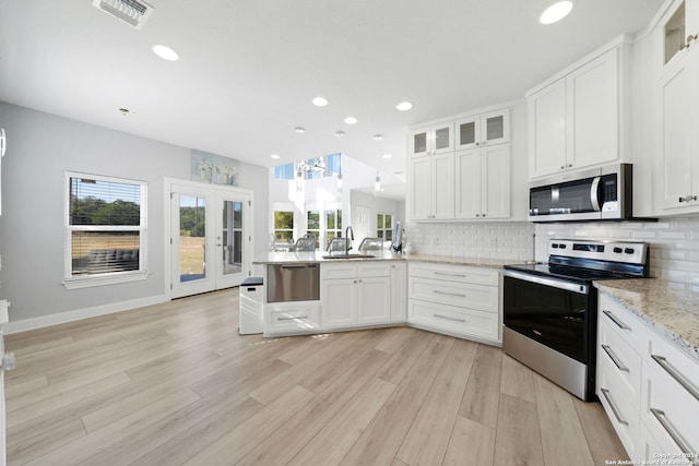 kitchen featuring appliances with stainless steel finishes, light hardwood / wood-style flooring, and white cabinetry