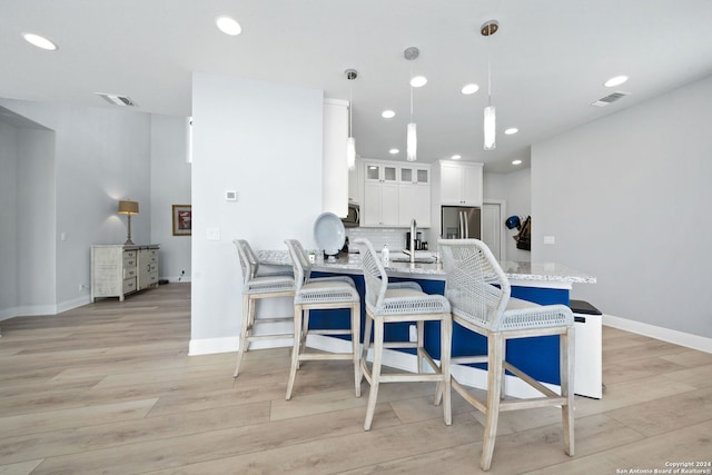 dining space with sink and light wood-type flooring