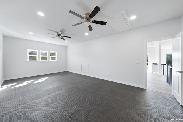 unfurnished room featuring ceiling fan and dark carpet