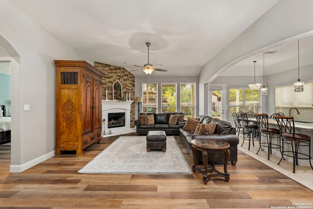 living room featuring lofted ceiling, hardwood / wood-style floors, and a fireplace