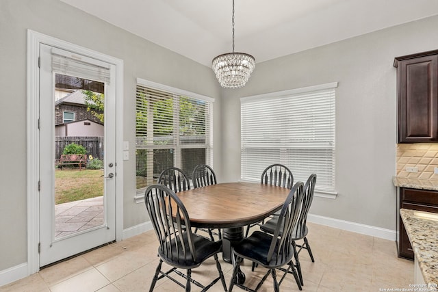 tiled dining room with an inviting chandelier