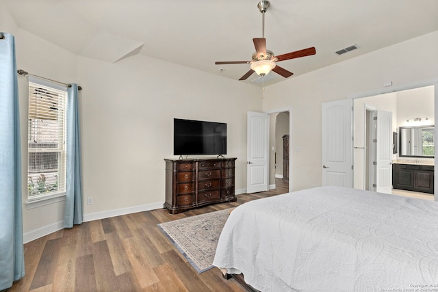 bedroom featuring ensuite bath, wood-type flooring, and ceiling fan