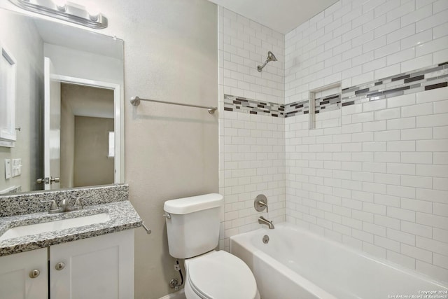 full bathroom with vanity, tiled shower / bath combo, and toilet