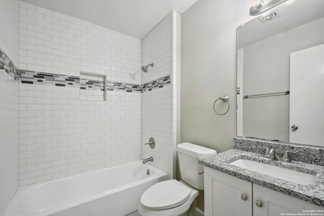 full bathroom featuring toilet, tiled shower / bath, and vanity