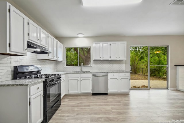 kitchen with a wealth of natural light, black range with gas stovetop, dishwasher, and white cabinetry