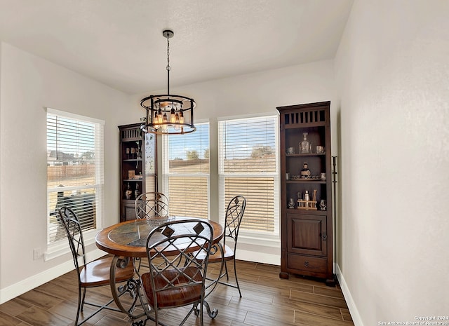 dining room featuring dark hardwood / wood-style flooring and a chandelier