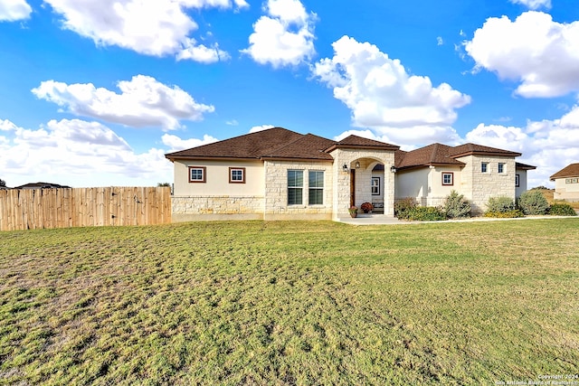 mediterranean / spanish home featuring a front lawn