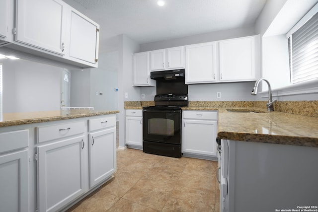 kitchen featuring range hood, sink, black / electric stove, and white cabinetry