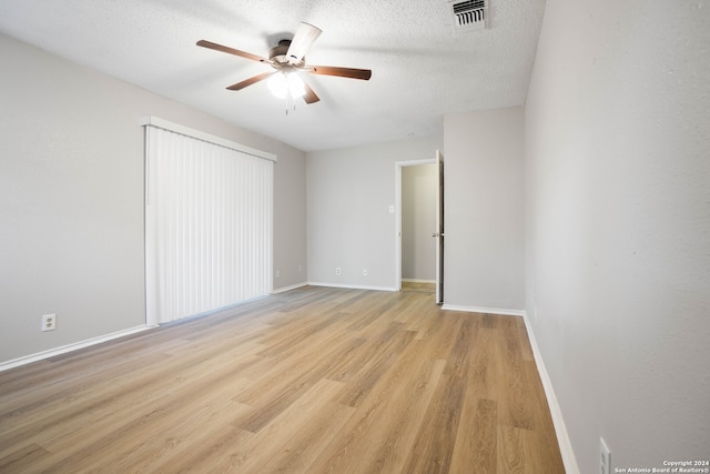 unfurnished bedroom with light hardwood / wood-style flooring, a textured ceiling, and ceiling fan