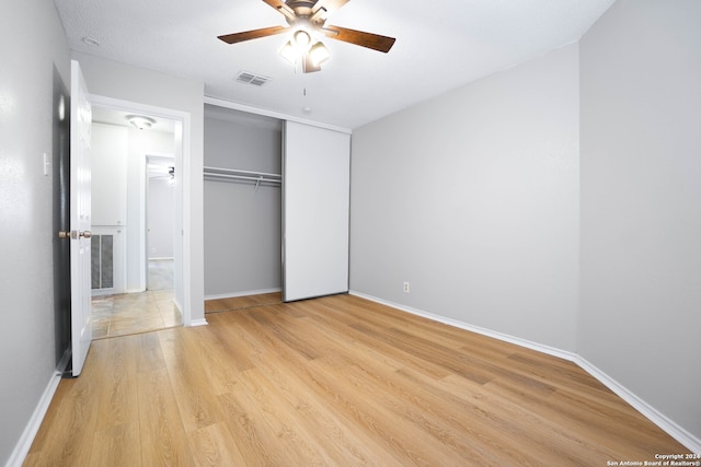 unfurnished bedroom with a closet, light wood-type flooring, and ceiling fan