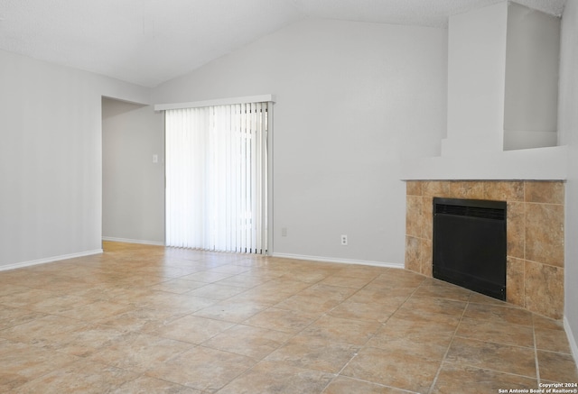 unfurnished living room with a textured ceiling, light tile patterned flooring, a fireplace, and vaulted ceiling