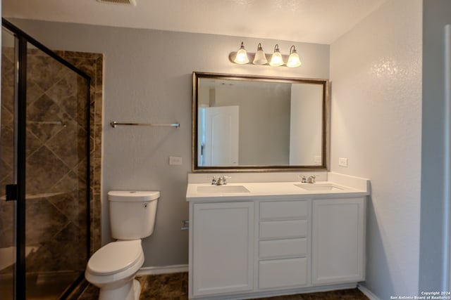 bathroom featuring toilet, an enclosed shower, and vanity