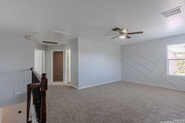 carpeted empty room featuring a textured ceiling and ceiling fan