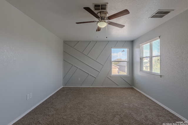 spare room with ceiling fan, carpet flooring, and a textured ceiling