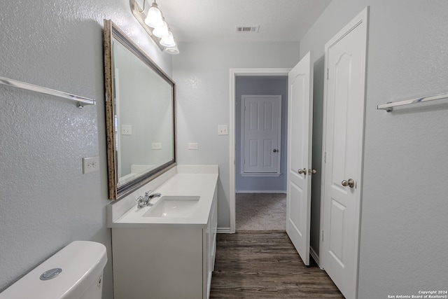 bathroom with vanity, hardwood / wood-style flooring, and toilet