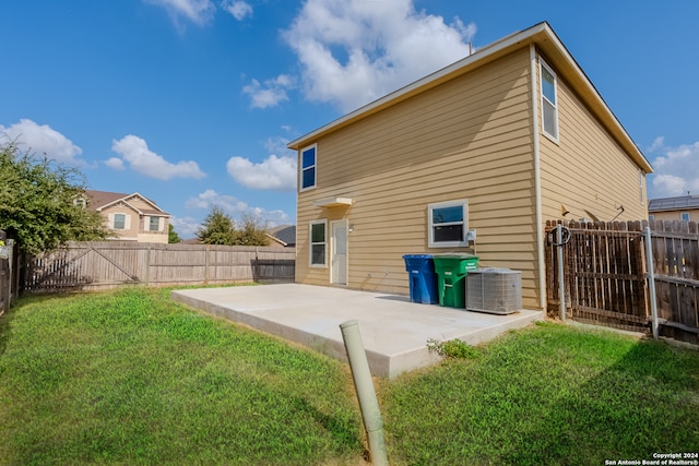 back of house with central AC unit, a patio area, and a lawn