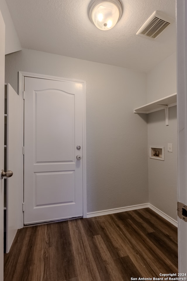 washroom featuring hookup for a washing machine, a textured ceiling, and dark hardwood / wood-style floors