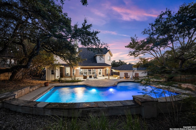 pool at dusk with a patio